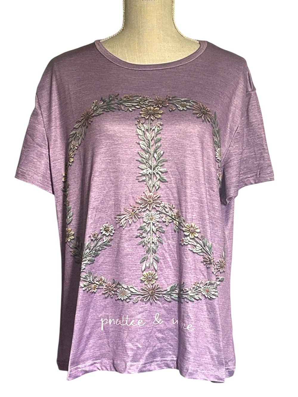 Purple short-sleeve shirt featuring a large floral & leaf peace sign graphic 1X